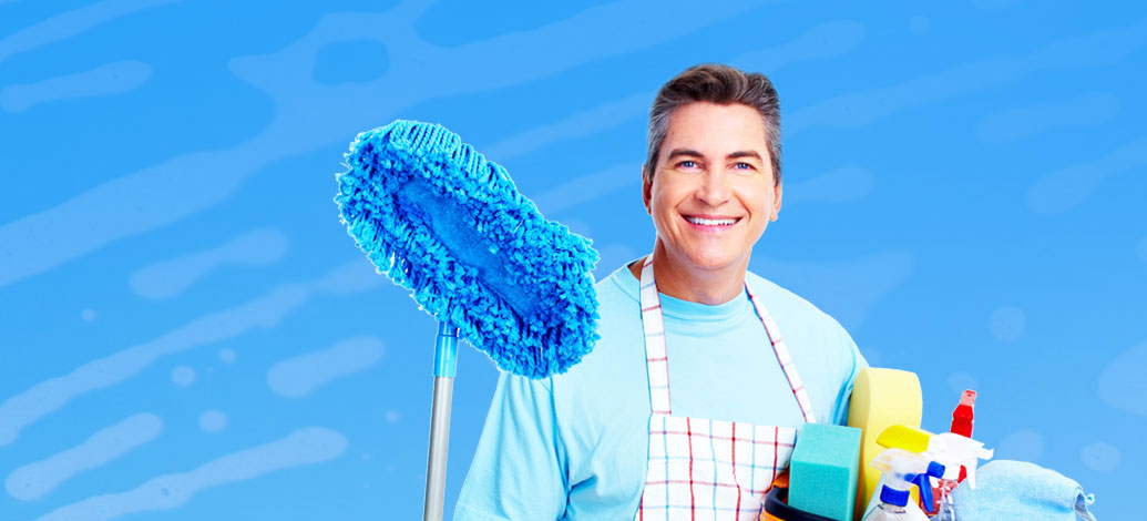 Smiling Male Cleaner with mop and cleaning equipments